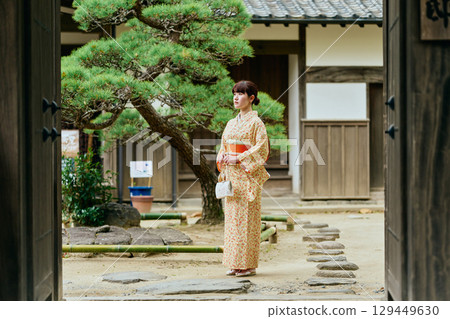 一位身穿和服的女子在花園裡漫步 129449630
