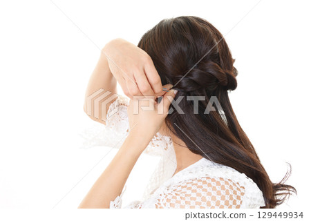 Back view of a woman doing a hair set 129449934