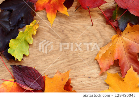 Autumn theme background with leaves over oak wood table with copy space Autumn theme background with leaves over oak wood table with copy space 129450045