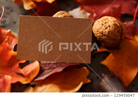 Autumn theme background with leaves over concrete with brown paper card Autumn theme background with leaves over concrete with brown paper card 129450047