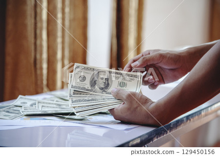 Hand holding loan money dollar bank note give financial payment. Man hands showing spread 100 dollar exchange cash payout. Saving Businessman counting money banknote bribe corruption concept. Hand holding loan money dollar bank note give financial payment. Man hands showing spread 100 dollar exchange cash payout. Saving Businessman counting money banknote bribe corruption concept. 129450156