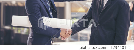 Teamwork partner two men team shaking hands together. Businessman contractor handshake with Business Partner Trust Partnership. Industrail people contractor dealing mission team meeting office desk 129450163
