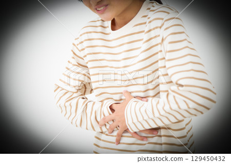 A middle school girl suffering from stomach pain A middle school girl suffering from stomach pain 129450432