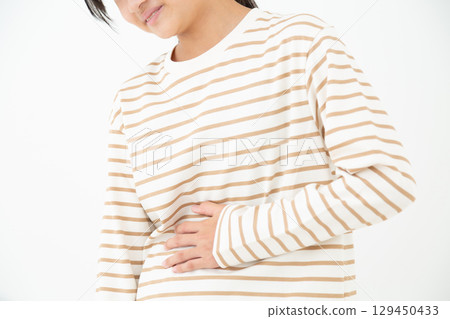 A middle school girl suffering from stomach pain A middle school girl suffering from stomach pain 129450433