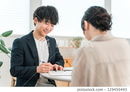 年輕的亞洲商人在談判桌上與女性客戶會面、諮詢和聽取意見 129450493