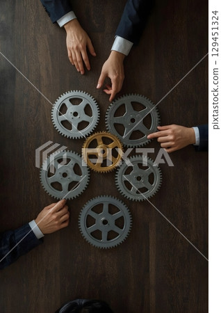 Top-Down View of Wooden Table with Interlocking Gears and Business Hands Teamwork Concept Illustration Top-Down View of Wooden Table with Interlocking Gears and Business Hands Teamwork Concept Illustration 129451324