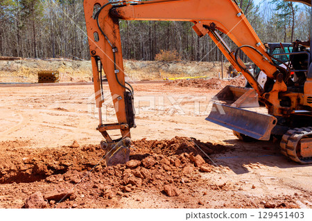 Excavator operates at construction site surrounded by construction site efficiently digs trench ground under works day 129451403