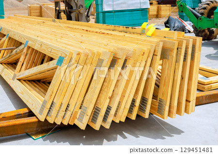 Workers prepare for big construction project using beams truss lumber in bustling urban environment under works day Workers prepare for big construction project using beams truss lumber in bustling urban environment under works day 129451481