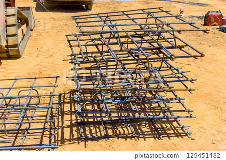 Reinforcing bars stacked neatly on construction site, ready for concrete work. Reinforcing bars stacked neatly on construction site, ready for concrete work. 129451482