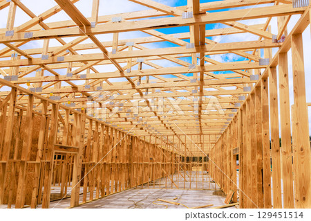 Workers are building wooden beams structure of new building on trusses roofing Workers are building wooden beams structure of new building on trusses roofing 129451514