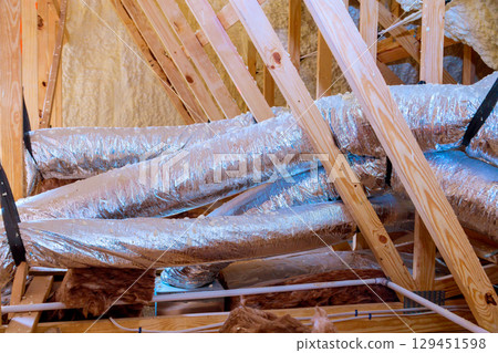 Installing insulated ductwork in residential attic during home renovation in new house Installing insulated ductwork in residential attic during home renovation in new house 129451598
