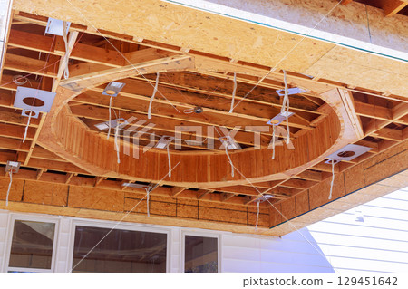 Craftsmen are assembling circular wooden ceiling feature in home addition under works day Craftsmen are assembling circular wooden ceiling feature in home addition under works day 129451642