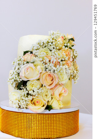 Gorgeous wedding cake with yellow icing, fresh roses, babys breath perfect for any festive occasion 129451769