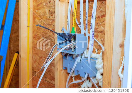 Electric wires are being connected in new home framing, installation process construction tools. Electric wires are being connected in new home framing, installation process construction tools. 129451808