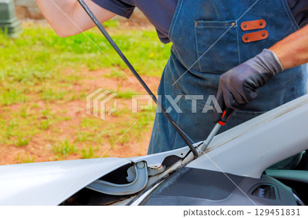 Mechanic working on auto window of vehicle, on repair under fixes car installation windshield Mechanic working on auto window of vehicle, on repair under fixes car installation windshield 129451831