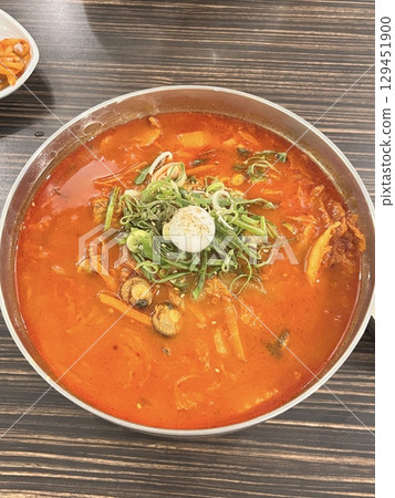 A steaming bowl of jjampong, the spicy Korean-Chinese noodle soup loaded with seafood, vegetables, and rich, flavorful broth. A hearty and satisfying comfort dish. 129451900