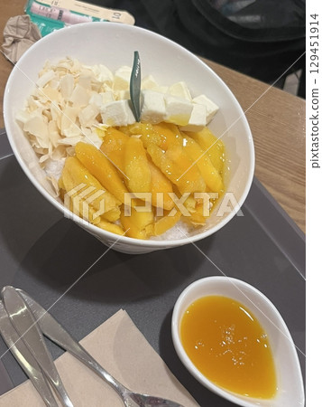 Refreshing mango bingsu with fluffy shaved ice, sweet mango chunks, and creamy condensed milk. A perfect Korean dessert for hot days, offering a delightful balance of fruity and creamy flavors! Refreshing mango bingsu with fluffy shaved ice, sweet mango chunks, and creamy condensed milk. A perfect Korean dessert for hot days, offering a delightful balance of fruity and creamy flavors! 129451914