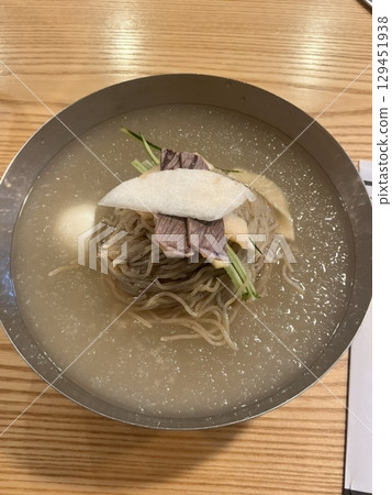 Authentic Pyongyang naengmyeon with chewy buckwheat noodles in cold, clear broth, offering a refreshing and delicate flavor. Perfect for traditional Korean cuisine menus and summer dishes. 129451938