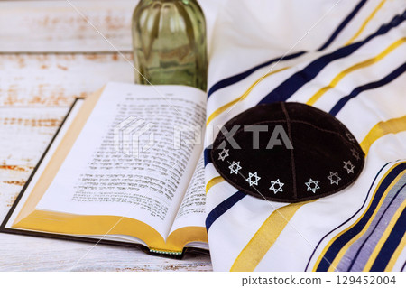 1 August 2025 Jerusalem Israel Kippah rests alongside Jewish prayer book tallit on rustic wooden surface in calming atmosphere synagogue "Hebrew Tanakh prayer holy book" 129452004
