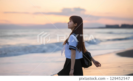 High school girls walking along the beach at sunset 129452547