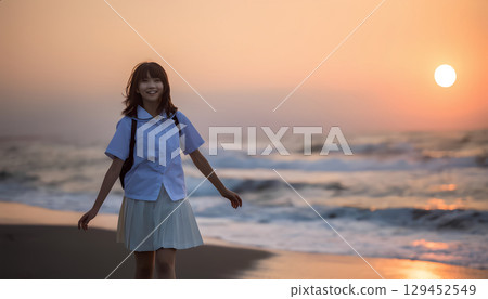 High school girls walking along the beach at sunset 129452549