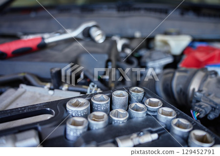 Socket wrench on car engine during maintenance work Socket wrench on car engine during maintenance work 129452791