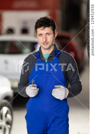 Service station man employee works in repair box, department Service station man employee works in repair box, department 129452938