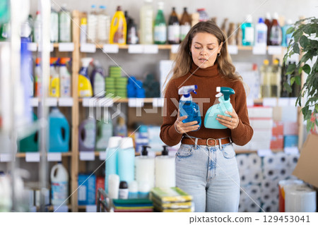 Young woman choosing cleaning spray in department store Young woman choosing cleaning spray in department store 129453041