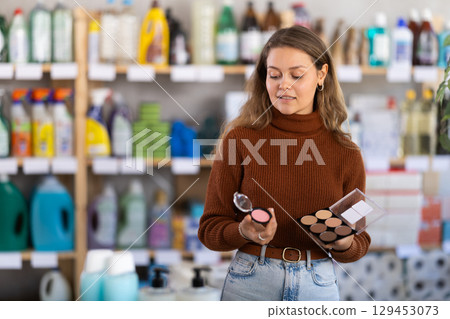 Young woman choosing blush and sculptor in store Young woman choosing blush and sculptor in store 129453073