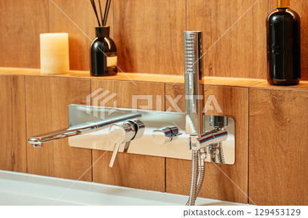 Modern chrome faucet and shower in wooden style bathroom interior Modern chrome faucet and shower in wooden style bathroom interior 129453129