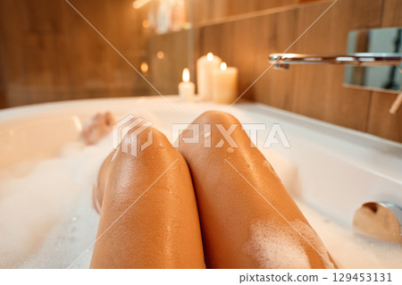 Woman relaxing in bathtub with foam 129453131