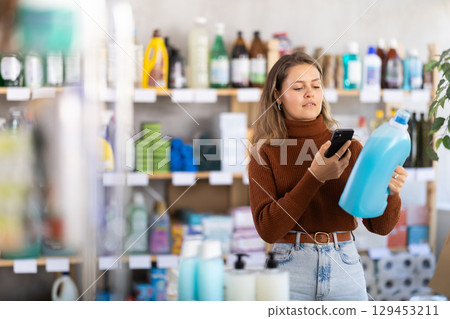 Young woman scanning qr code for detergent 129453211