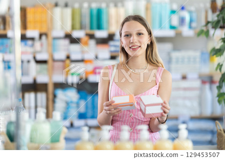 Girl in summer clothes looking for medicine in pharmacy 129453507