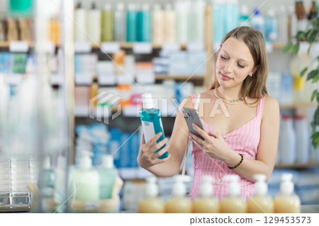 Young woman scanning qr code of mouthwash 129453573