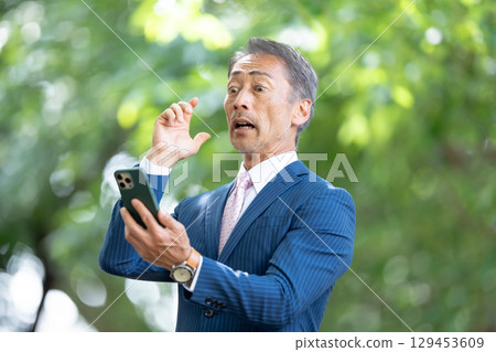 Businessman, fresh greenery, smartphone, surprised Businessman, fresh greenery, smartphone, surprised 129453609