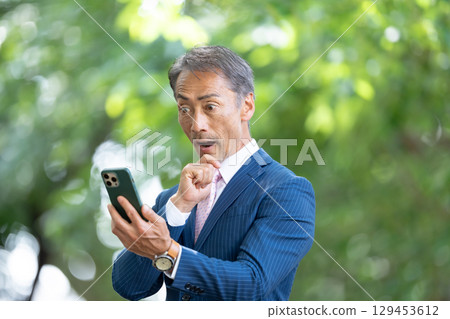 Businessman, fresh greenery, smartphone, surprised 129453612