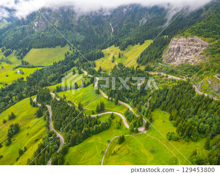 Experience the breathtaking beauty of the Swiss Alps with these winding serpentine roads. Perfect for an adventure-filled road trip, the lush greenery and mountainous backdrop invite exploration. 129453800