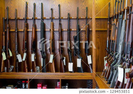Gun store interior with rifles on showcase 129453851
