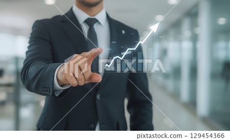 Businessman Pointing at Virtual Financial Growth Interface in Modern Office 129454366