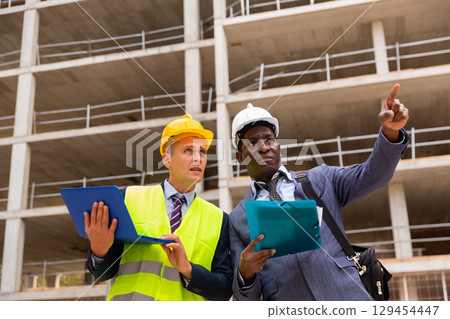Engineer and foreman discussing new project on construction site 129454447