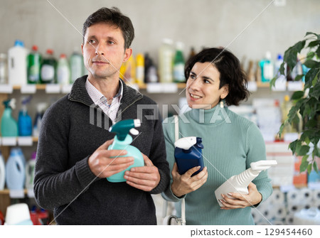 Couple man and woman choosing cleaning spray in store Couple man and woman choosing cleaning spray in store 129454460