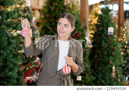 Woman purchasing decorations at christmas fair shop 129454526