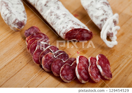 Slicing delicious Spanish smoked sausage fuete Slicing delicious Spanish smoked sausage fuete 129454529