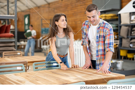 Spouses buyer choose table desk in garden furniture store showroom 129454537