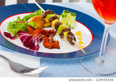 Fried chicken heart skewers with avocado and fried chanterelles served at plate Fried chicken heart skewers with avocado and fried chanterelles served at plate 129454548