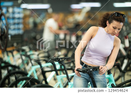 Adult woman choosing bike in store 129454624