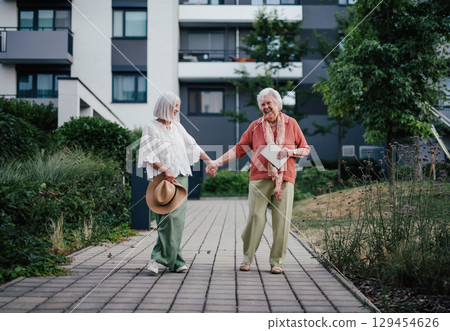 Older woman enjoying a walk with her aging mother. Older woman enjoying a walk with her aging mother. 129454626