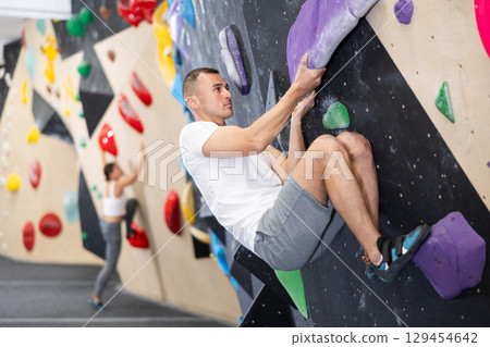 Man climbs steep artificial wall in sports complex and trains endurance 129454642