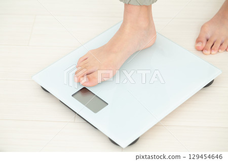 A middle school girl riding a weight scale A middle school girl riding a weight scale 129454646