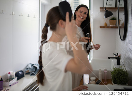 Mother talking with daughter during skincare routine 129454711